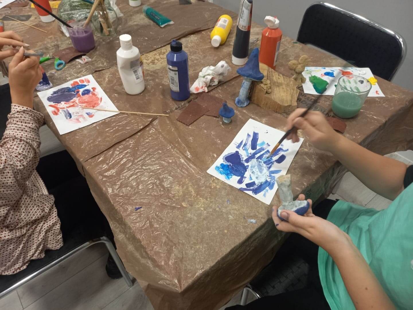 Zdjęcie przedstawia malujące dziecko podczas warsztatów artystycznych